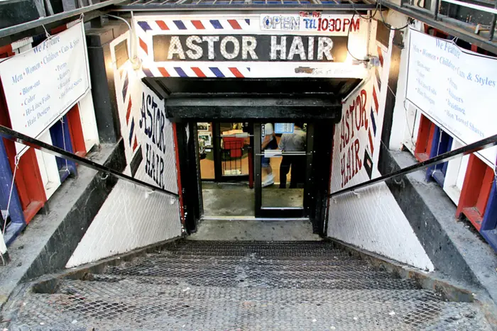 Stairs lead down to the basement entrance to Astor Hair.